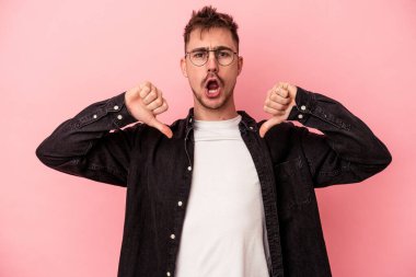 Pembe arka planda izole edilmiş genç beyaz adam gururlu ve kendinden emin hissediyor, örnek olarak.