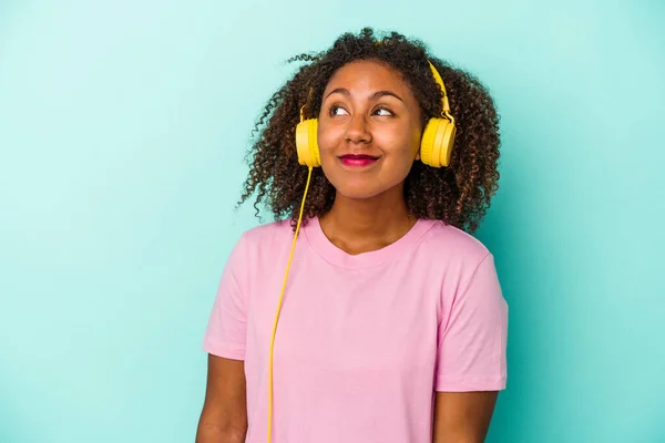 Jovem Afro Americana Ouvindo Música Isolada Fundo Azul Sonhando Alcançar — Fotografia de Stock