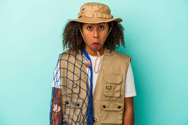 Young African American Fisherwoman Holding Net Isolated Blue Background Shrugs — Stock Photo, Image