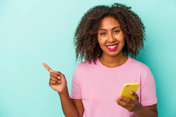 Joven Mujer Afroamericana Sosteniendo Teléfono Móvil Aislado Sobre Fondo Azul —  Fotos de Stock