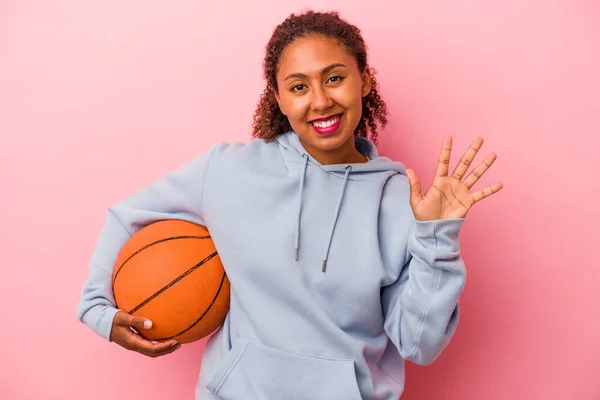 Joven Afroamericano Jugando Baloncesto Aislado Sobre Fondo Rosa Sonriente Alegre — Foto de Stock