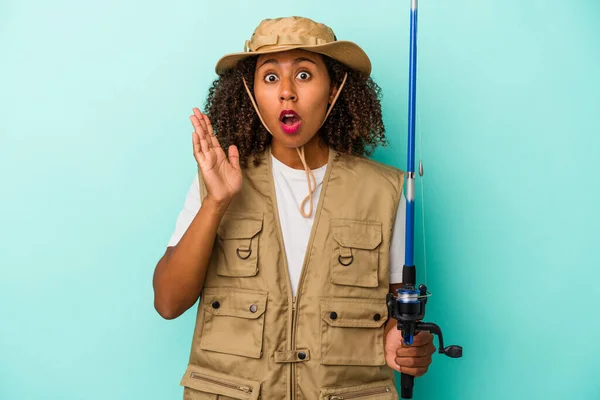 Young African American Fisherwoman Holding Rod Isolated Blue Background Surprised — Stock Photo, Image