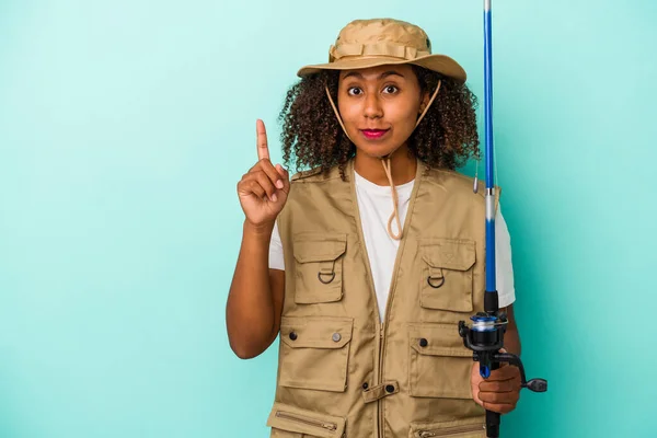 Young African American Fisherwoman Holding Rod Isolated Blue Background Showing — Stock Photo, Image