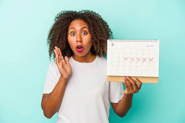 Giovane Donna Afroamericana Possesso Calendario Isolato Sfondo Blu Sorpreso Scioccato — Foto Stock