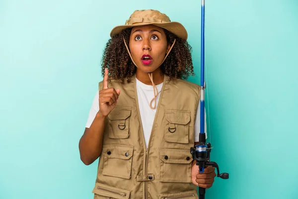 Young African American Fisherwoman Holding Rod Isolated Blue Background Pointing — Stock Photo, Image
