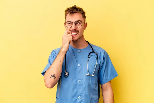 Νεαρός Νοσοκόμος Καυκάσιος Άνδρας Απομονωμένος Κίτρινο Φόντο Δαγκώνει Νύχια Νευρικός — Φωτογραφία Αρχείου
