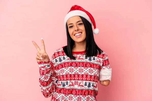 年轻的高加索女人 只有一只手 用粉红的背景欢快地 无忧无虑地伸出来庆祝圣诞节 用手指展示和平的象征 — 图库照片