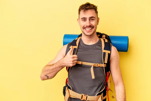 Jovem Caminhante Caucasiano Homem Isolado Fundo Amarelo Sorrindo Levantando Polegar — Fotografia de Stock