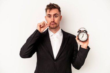 Beyaz arka planda çalar saati tutan Kafkasyalı genç bir iş adamı. Parmakları dudaklarında bir sır saklıyor..