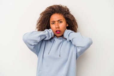 Beyaz arka planda izole edilmiş kıvırcık saçlı, genç Afrikalı Amerikalı kadın kafasının arkasına dokunuyor, düşünüyor ve bir seçim yapıyor..