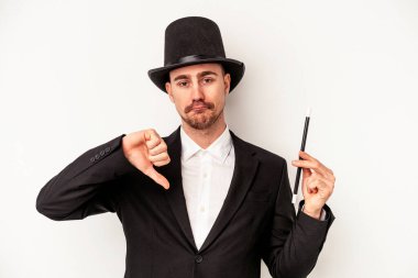 Beyaz arka planda saklanmış beyaz bir değnek tutan Kafkasyalı genç büyücü hoş olmayan bir jest gösteriyor, kabul etmiyor. Anlaşmazlık konsepti.