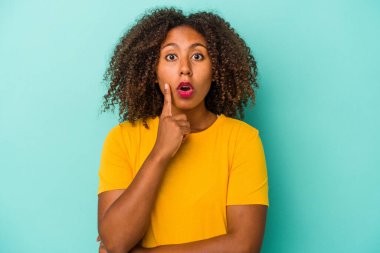 Mavi arka planda izole edilmiş kıvırcık saçlı Afro-Amerikalı genç bir kadın. Harika bir fikri var, yaratıcılık kavramı..
