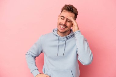 Pembe arka planda izole edilmiş genç beyaz bir adam neşeli bir şekilde gülüyor. Mutluluk kavramı.