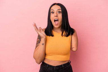 Tek kollu beyaz bir kadın pembe arka planda izole edilmiş, şaşırmış ve şok olmuş..