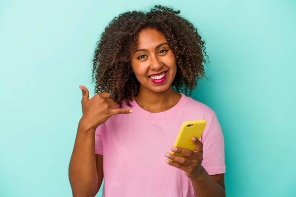 Joven Mujer Afroamericana Sosteniendo Teléfono Móvil Aislado Sobre Fondo Azul —  Fotos de Stock