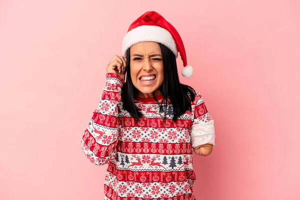 若いですCaucasian女性とともに一つの腕お祝いクリスマス隔離されたピンクの背景カバー耳で手 — ストック写真