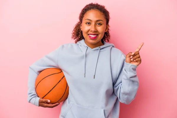 Joven Afroamericano Jugando Baloncesto Aislado Sobre Fondo Rosa Sonriendo Señalando — Foto de Stock