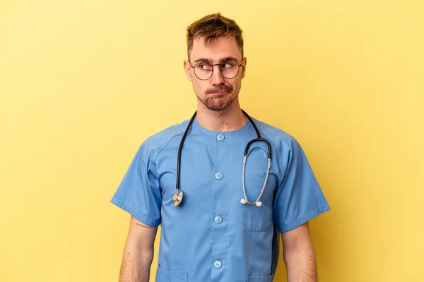 Jovem Enfermeira Caucasiano Homem Isolado Fundo Amarelo Confuso Sente Duvidoso — Fotografia de Stock