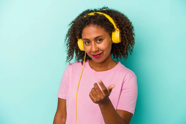 Jovem Afro Americana Ouvindo Música Isolada Fundo Azul Apontando Com — Fotografia de Stock