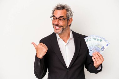 Elinde banknotlar tutan orta yaşlı bir iş adamı mavi arka planda, parmak uzakta, gülen ve kaygısız..