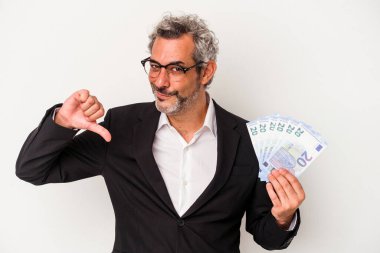 Elinde banknotlar tutan orta yaşlı bir iş adamı gururlu ve kendinden emin hissediyor, örnek olarak..
