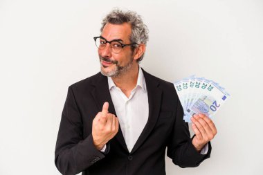 Elinde banknotlar tutan orta yaşlı bir iş adamı mavi arka planda seni işaret ediyor sanki davet ediliyormuş gibi..