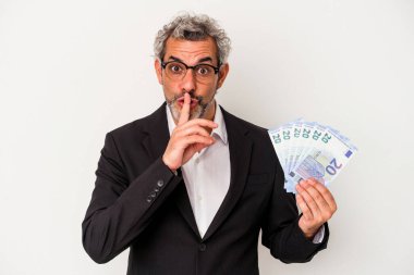 Elinde banknotlar tutan orta yaşlı bir iş adamı mavi arka planda bir sır saklıyor ya da sessizlik istiyor..