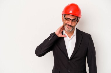 Orta yaşlı mimar beyaz arka planda izole edilmiş beyaz bir adam kafasının arkasına dokunuyor, düşünüyor ve bir seçim yapıyor..