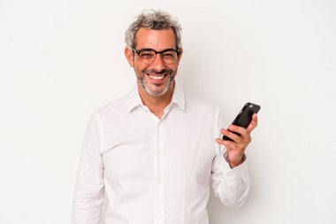 Beyaz arka planda izole edilmiş, mutlu, güler yüzlü ve neşeli bir cep telefonu tutan orta yaşlı beyaz iş adamı..