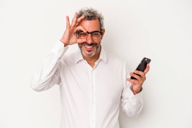 Beyaz arka planda izole edilmiş bir cep telefonu tutan orta yaşlı beyaz iş adamı..
