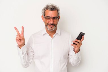 Beyaz arka planda iki numaranın parmakları olduğunu gösteren bir cep telefonu tutan orta yaşlı beyaz iş adamı..