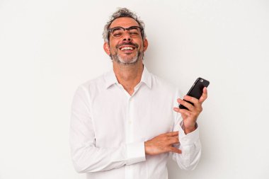 Beyaz arka planda izole edilmiş cep telefonu tutan beyaz iş adamı gülüyor ve eğleniyor..