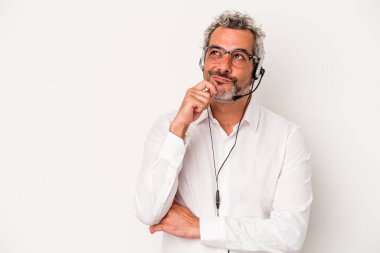 Beyaz arka planda izole edilmiş, şüpheli ve şüpheci bir ifadeyle yan bakan orta yaşlı bir beyaz pazarlamacı..