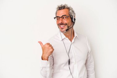 Orta yaşlı beyaz pazarlamacı beyaz arka planda izole edilmiş, baş parmak uzakta, gülen ve kaygısız..