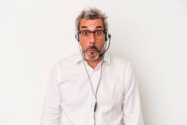 Orta yaşlı pazarlamacı beyaz arka planda izole edilmiş beyaz bir beyaz adam omuzlarını silker ve gözleri açık kalır..