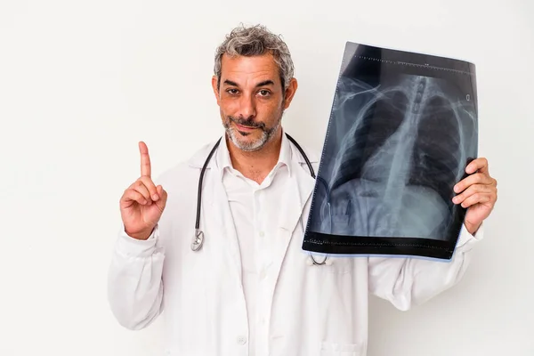 中年医師白地に隔離された放射線撮影を保持している白人男性指でナンバーワンを示す — ストック写真