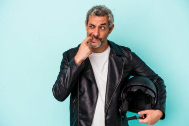 Mavi arka planda izole edilmiş kaskı olan orta yaşlı motorcu beyaz adam bir şeyin fotokopi alanına baktığını düşünerek rahatladı..