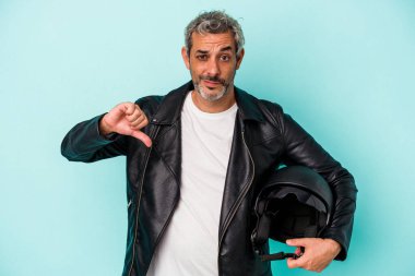 Mavi arka planda izole edilmiş miğfer tutan orta yaşlı beyaz bir motosikletli adam hoşlanmadığı bir hareket gösteriyor. Anlaşmazlık konsepti.