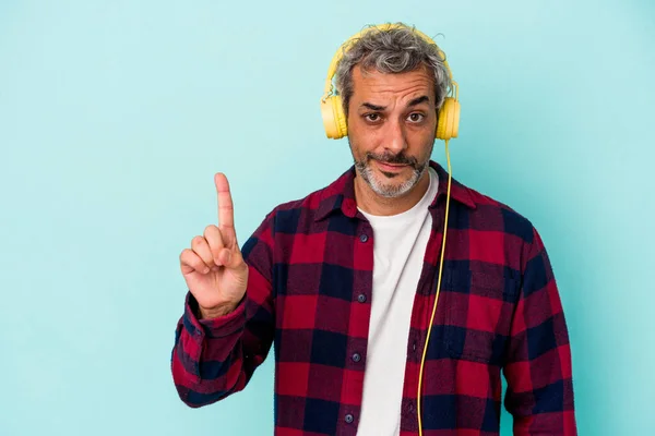 Medelålders Kaukasier Man Lyssnar Musik Isolerad Blå Bakgrund Visar Nummer — Stockfoto