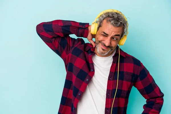 Medelålders Kaukasisk Man Lyssnar Musik Isolerad Blå Bakgrund Vidröra Baksidan — Stockfoto