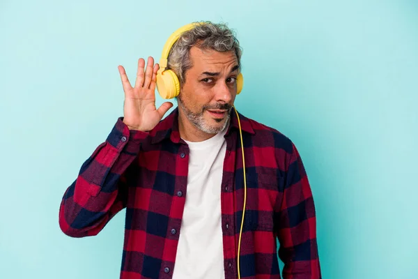 Medelålders Kaukasier Man Lyssnar Musik Isolerad Blå Bakgrund Försöker Lyssna — Stockfoto