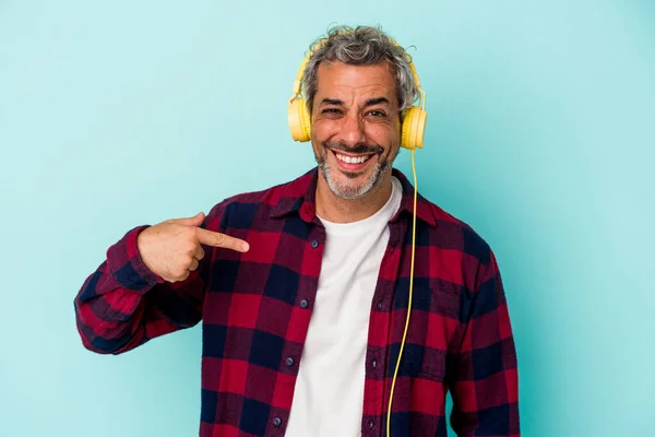 Medelålders Kaukasisk Man Lyssnar Musik Isolerad Blå Bakgrund Person Pekar — Stockfoto