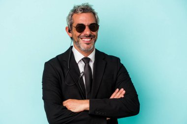 Orta yaşlı koruma beyaz adam mavi arka planda izole edilmiş gülüyor ve eğleniyor..