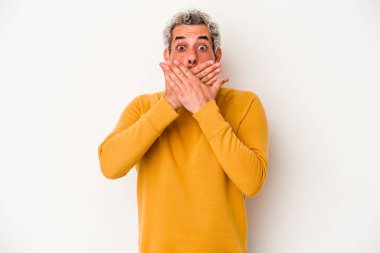 Beyaz arka planda izole edilmiş orta yaşlı beyaz bir adam elleriyle ağzını kapatırken şok oldu..