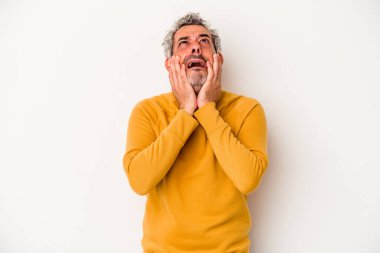 Beyaz arka planda, ağlayan ve sızlanan orta yaşlı, beyaz bir adam var..