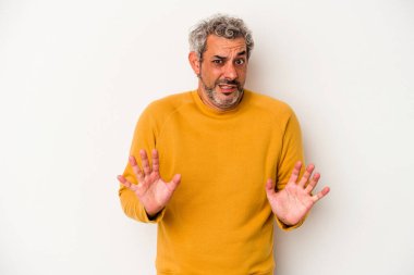 Beyaz arka planda izole edilmiş orta yaşlı beyaz bir adam tiksinti belirtisi gösteren birini reddediyor..