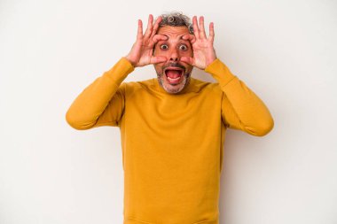 Beyaz arka planda izole edilmiş orta yaşlı beyaz bir adam bir başarı fırsatı bulmak için gözlerini açık tutuyor..