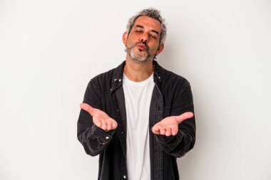 Beyaz arka planda izole edilmiş orta yaşlı beyaz bir adam dudaklarını katlıyor ve hava öpücüğü vermek için avuç içi tutuyor..