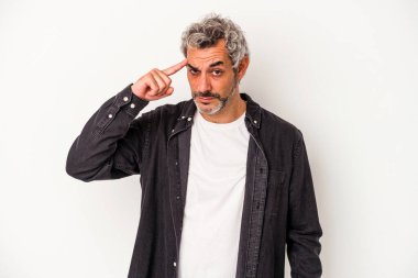 Beyaz arka planda izole edilmiş orta yaşlı beyaz bir adam şakağı parmağıyla işaret ediyor, düşünüyor ve bir göreve odaklanıyor..