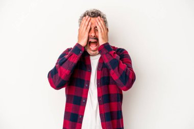 Beyaz arka planda izole edilmiş orta yaşlı beyaz bir adam yüzünün yarısını palmiye ile örterek eğleniyor..